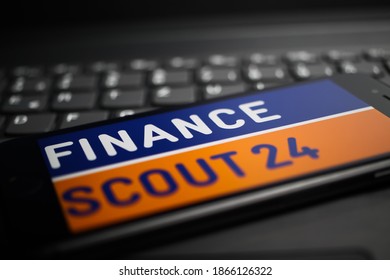Viersen, Germany - April 9. 2020: Close up of mobile phone screen with logo lettering of Financescout24 comparison portal on computer keyboard, 50 Euro money background (selective focus on letter A)