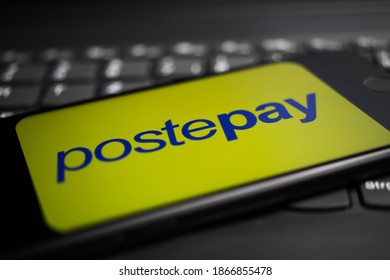 Viersen, Germany - April 9. 2020: Close up of mobile phone screen with logo lettering of postepay  payment provider on computer keyboard (selective focus on letter e)