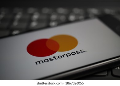 Viersen, Germany - April 9. 2020: Close up of mobile phone screen with logo lettering of Masterpass payment provider on computer keyboard (selective focus on letter r, no altered editorial)