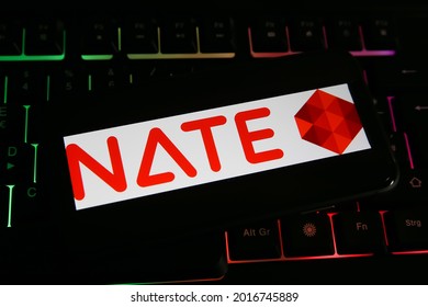 Viersen, Germany - June 1. 2021: Closeup of mobile phone screen with logo lettering of korean nate web portal on computer keyboard (focus on letter T)