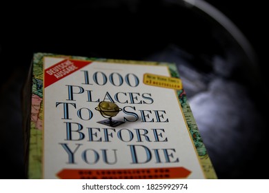 Viersen, Germany - May 9. 2020: View On Isoalted Book Cover 1000 Places To See Before You Die With Blurred World Globe Background (focus On Center Of Cover)