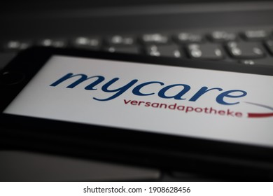 Viersen, Germany - May 9. 2020: Close up of mobile phone screen on computer keyboard with logo lettering of german online mail-order pharmacy mycare (focus on letter c lower left part)