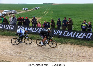 Viesly, France - April 14, 2019: Two Cyclists (Matteo Trentin Of Mitchelton-Scott Team And Yves Lampaert Of Deceuninck-Quick Step Team) Riding On A Cobblestone Road During Paris Roubaix 2019.