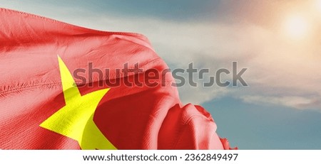 Vietnam national flag cloth fabric waving on beautiful sky Background.