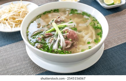 Vietnam traditional pho, Beef noodles. Pho Bo Soup with beef, rice noodles, ginger, lime, chili pepper in bowl. Vietnamese cuisine. Pho Noodle Soup - Powered by Shutterstock