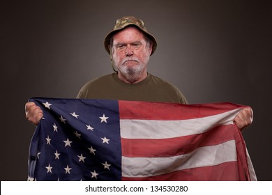 Vietnam Veteran Holding An American Flag