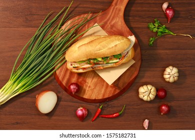 Vietnamese bread in wooden background, the most favorite street food, makes sandwiches with meat, spring rolls, eggs, cucumbers. fresh hear and sauce