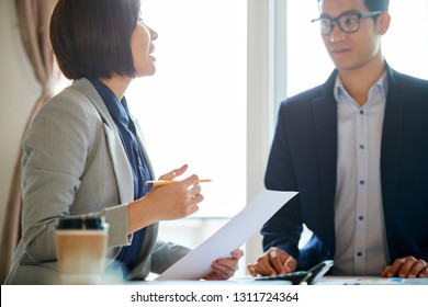 Vietnamese business people talking and reaching general consensus at meeting - Shutterstock ID 1311724364