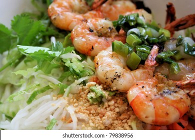 Vietnamese cuisine grilled shrimp on bed of rice noodles and greens, topped with seasoned onions.