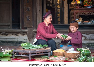 Vietnamese Family Members Making Banh Chung Together On Old-styled House Yard. Chung Cake Is A Very Well-known Dish That Could Never Miss On The Altar, And Family Meal Of Vietnamese During Tet Holiday