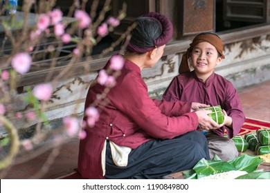 Vietnamese Family Members Making Banh Chung Together On Old-styled House Yard. Chung Cake Is A Very Well-known Dish That Could Never Miss On The Altar, And Family Meal Of Vietnamese During Tet Holiday