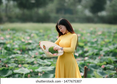 Vietnamese girl holding a lotus flower, The Ao dai ( long-dress Vietnamese) is traditional costume of Vietnamese woman - Powered by Shutterstock