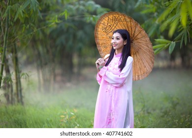 Vietnamese girl traditional dress holding an umbella , Ao dai is famous traditional costume for woman in Vietnam