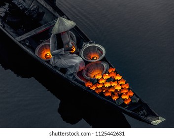 Vietnamese girls set fire to ritual lanterns, which they send to sail on the river at night to urge luck. Bridge survey. Hue city. Vietnam - Powered by Shutterstock