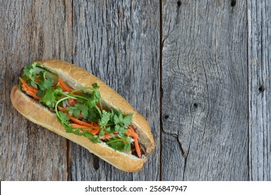 Vietnamese Grilled Pork Banh Mi Sandwich on Rustic Wood Background