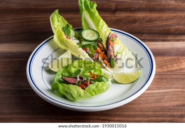 Vietnamese lettuce wraps. Japanese or Thai cuisine\
entree favorites. Lettuce wraps made with noodles, pork, chicken,\
tofu, scallions, cilantro, sprouts, eggs, limes, jalapeños, peanut\
and sauce.