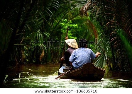 vietnamese people paddling in the Mekong river, Vietnam