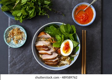 Vietnamese Pho With Duck With Crispy Skin, Bean Sprouts And Egg, Chili Sauce And Herbs