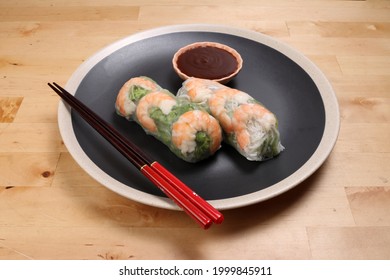 Vietnamese Prawn Shrimp See Through Rice Paper Spring Roll Green Vegetable Sauce On Dark Plate Chopsticks Wooden Table