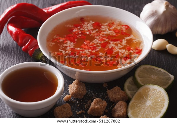 Vietnamese spicy sauce Nuoc Cham with the\
ingredients in a bowl close-up.\
Horizontal\
