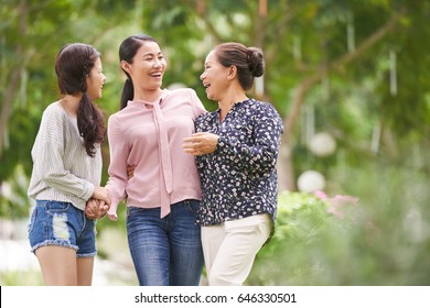 Vietnamese Teen Girl With Mother And Grandmother Walking Outdoors And Laughing