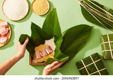 Vietnamese traditional Chung cake with dong leaf pork glutinous rice in green background for holiday food advertising , top view