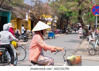 Vietnamese Woman Cycling At Hoi An Old Town, Vietnam.