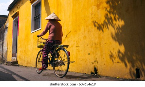 Vietnamese Woman Cycling At Hoi An Old Town, Vietnam.