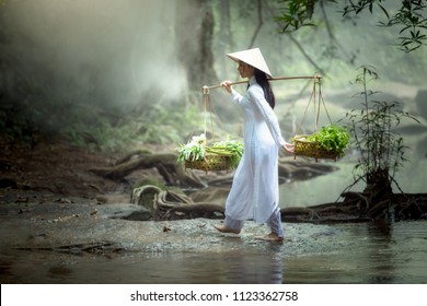 Vietnamese Woman holding cart walking for sale vegetables this is lifestyle of Vietnam people in the past - Shutterstock ID 1123362758