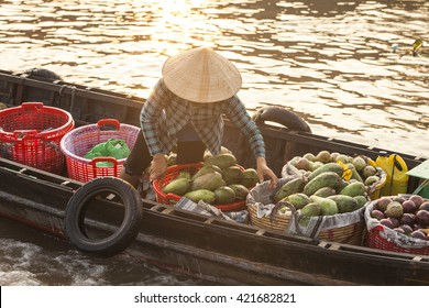 Vietnamese Woman On A Wood Boat Selling Fruits And Vegetables On Cai Rang Floating Market In The Can Tho City, Mekong Delta. Sunset Light