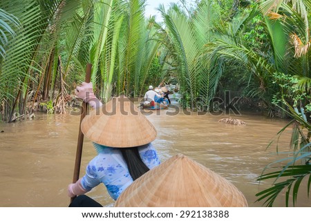 Vietnamese woman paddling in the Mekong River