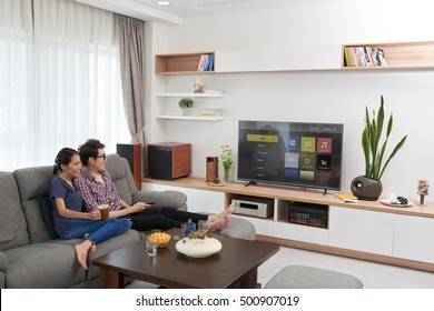 Vietnamese Young Couple Watching Smart Tv At Home