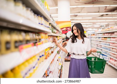 Vietnamese Young Lady Choosing Products At Supermarket