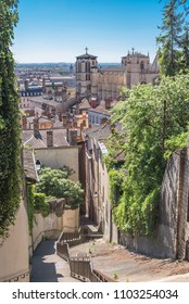 Vieux-Lyon, an old pathway with steps in the old town, Saint-Jean-Baptiste cathedral in background
