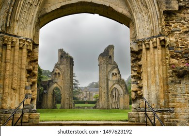 View of Abbey House and ruins of the Great Church from Lady Chapel at Glastonbury Abbey monastery in pouring rain in Glastonbury, England - June 13, 2019