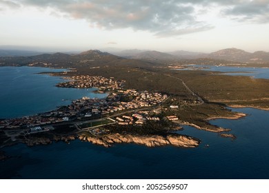 View from above, aerial shot, stunning panoramic view of Golfo Aranci during a beautiful sunrise. Golfo Aranci is a village that extends along a strip of land into turquoise sea. Sardinia, Italy. - Shutterstock ID 2052569507