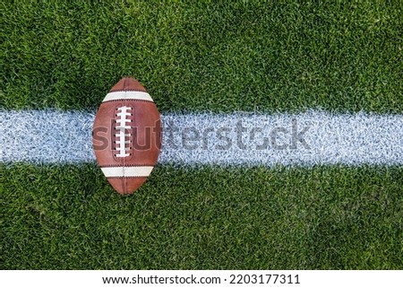 View from above of an American Football sitting on a grass football field on the yard line. Generic Sports image	