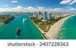 View from above of big container ship entering main channel in Miami harbor near South Beach high luxurious hotels and apartment buildings