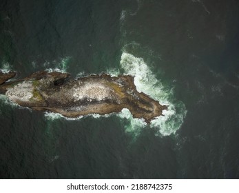 View From Above. A Bizarre Island In The Middle Of The Ocean. Turquoise Water And White Foamy Waves Crash Against The Island. Romance, Travel, Ecology. Advertising Of Tourist Destinations.