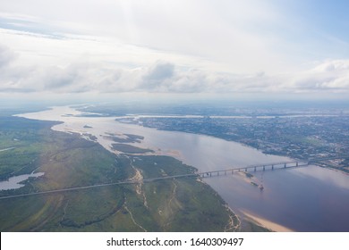 View From Above. The Border City Of Blagoveshchensk From An Airplane Window. A Bridge Over The Amur River, Connecting Russia And China.