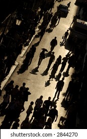 View From Above Of Busy Street With People Walking Silhouetted Against Golden Light In Rome Italy