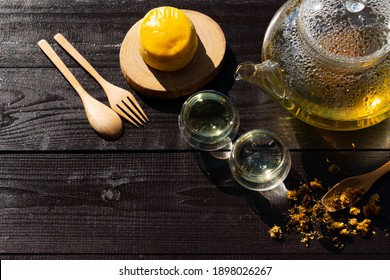 View From Above Of Chrysanthemum Tea In Glass Kettle With Cup And Scone For Afternoon Tea Party In Garden