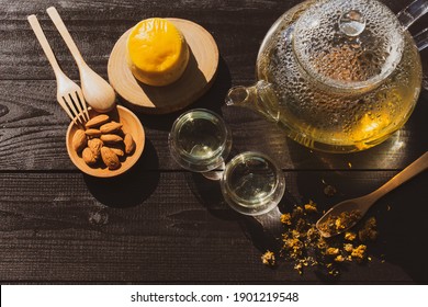 View From Above Of Chrysanthemum Tea In Glass Kettle With Cup And Scone With Almond For Afternoon Tea Party In Garden