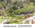 View from above cliff edge of winding road and cars Cheddar Gorge in Somerset.