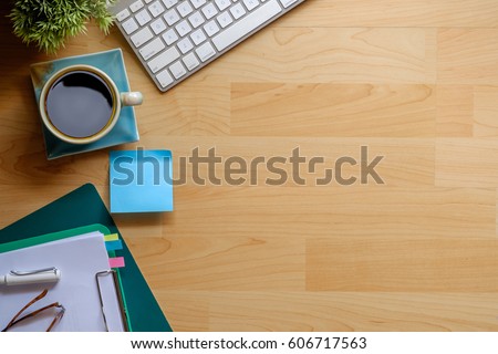 View from above with copy space of  notepad, computer and coffee cup on wood work table.