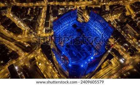 View from above of the Costanera Center Building; night photography where you can see a part of the city of Santiago. The yellow color of the lights contrasts with the blue color of the building.