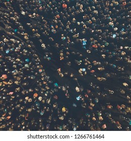 A View From Above To The Crowd Of People Gathering For An Event. Crowed Open-air Meeting Of People Shot From A Height. Night-time Gathering Of A Lot Of People Celebrating An Event. Merrymaking