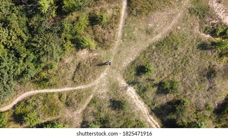 View From Above Of A Drone Pilot Who Is Standing In The Middle Of Small Paths And Holding The Control Device.