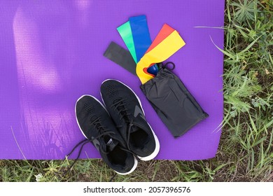 View From Above Of Fitness And Sport Equipment. Sneakers, Elastic Rubber Band On Exercise Mat Background Outdoor, Top View. Healthy Lifestyle Concept. 