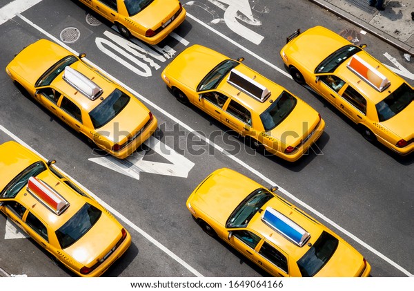 View from above of fleet of\
yellow taxi cabs driving down the street of Broadway in New York\
City